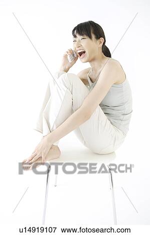 A young woman talking over a phone View Large Photo Image Stock Photo - A young woman talking over a phone. Fotosearch