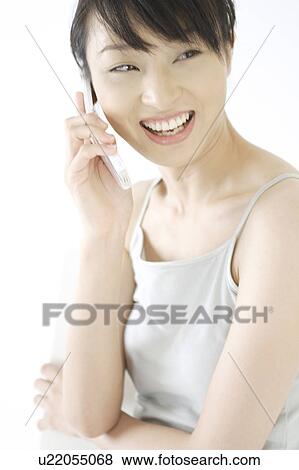 A young woman talking over a phone View Large Photo Image Stock Photo - A young woman talking over a phone. Fotosearch