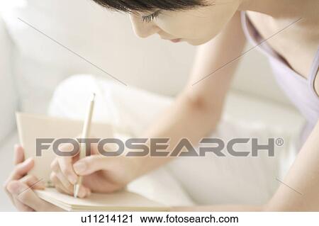Stock Image - A young woman writing. Fotosearch