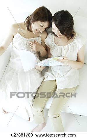Two young women reading a book View Large Photo Image Stock Image - Two young women reading a book. Fotosearch