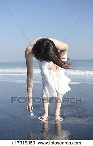 Stock Photo - A young woman in beach. Fotosearch