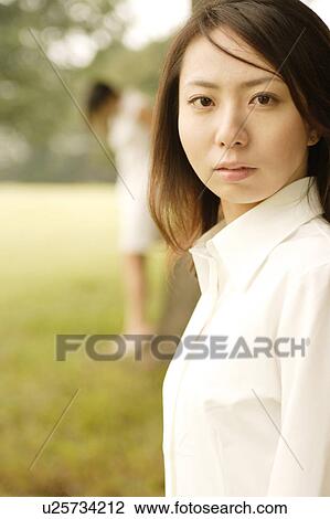 Stock Image - A young woman looking at a camera. Fotosearch