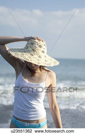 Stock Image - A young woman wearing a hat in beach. Fotosearch