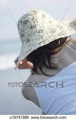 A young woman wearing a hat in beach, rear view View Large Photo Image Stock Photo - A young woman wearing a hat in beach, rear view. Fotosearch