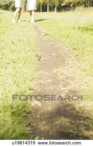 Two women standing in park View Large Photo Image Stock Photo - Two women standing in park. Fotosearch