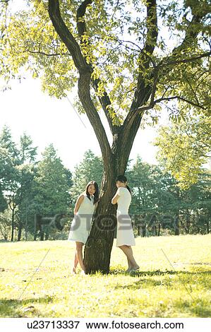 Stock Photo - Two women standing in park. Fotosearch