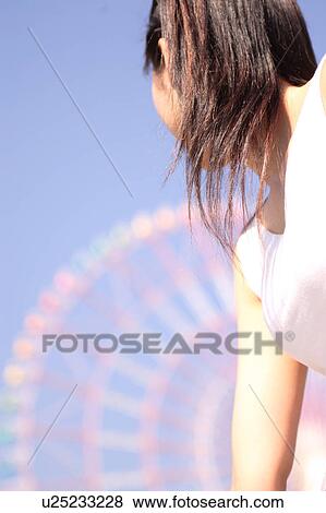 A woman in front of Ferris Wheel, Rear View View Large Photo Image Stock Photo - A woman in front of Ferris Wheel, Rear View. Fotosearch