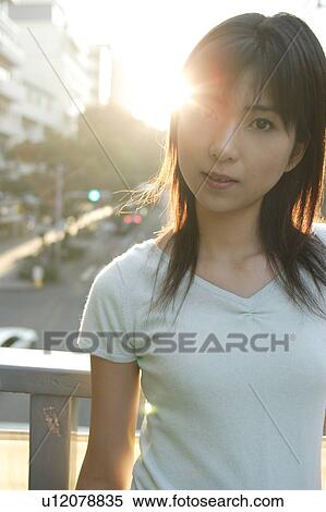 Stock Photography - A young woman looking at a camera. Fotosearch