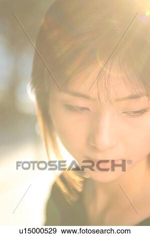 A young woman looking down, close-up View Large Photo Image Stock Photo - A young woman looking down, close-up. Fotosearch