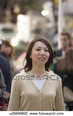 A young woman walking in street View Large Photo Image Stock Image - A young woman walking in street. Fotosearch