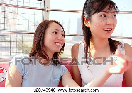 Stock Image - Two women in Ferris Wheel. Fotosearch