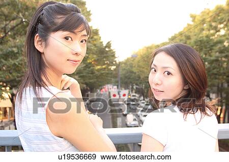 Stock Photo - Two women looking at a camera. Fotosearch