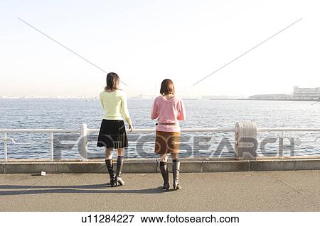 Stock Photo - Two women standing at port. Fotosearch