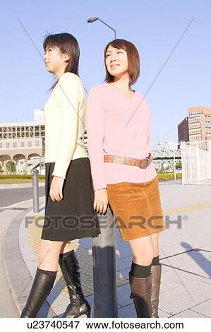 Two women standing in front of Ferris Wheel View Large Photo Image Stock Photo - Two women standing in front of Ferris Wheel. Fotosearch