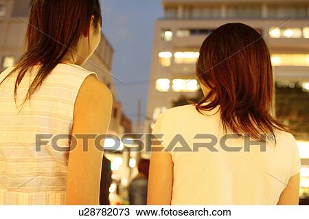 Two women walking at dusk View Large Photo Image Stock Image - Two women walking at dusk. Fotosearch