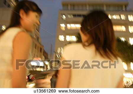 Two women walking at dusk View Large Photo Image Stock Photo - Two women walking at dusk. Fotosearch