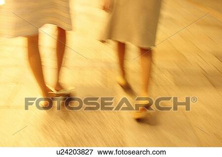Stock Photo - Two women walking at dusk. Fotosearch