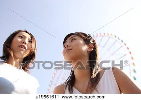Stock Image - Two women with Ferris Wheel. Fotosearch