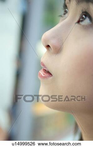Stock Photograph - Young woman looking up. Fotosearch