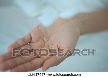 Stock Photo - A woman's hand with moisturizer, close up. Fotosearch