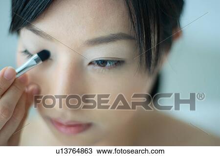 A young woman applying eye makeup, close-up View Large Photo Image Stock Image - A young woman applying eye makeup, close-up. Fotosearch