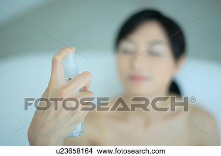 A young woman applying lotion to her face View Large Photo Image Picture - A young woman applying lotion to her face. Fotosearch