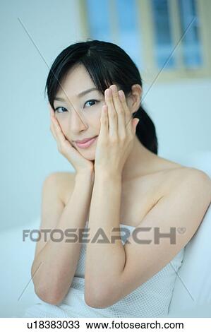 A young woman applying lotion to her face View Large Photo Image Stock Image - A young woman applying lotion to her face. Fotosearch