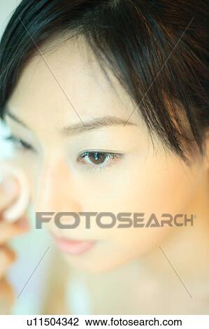 A young woman applying makeup, close-up View Large Photo Image Stock Image - A young woman applying makeup, close-up. Fotosearch