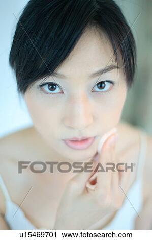 A young woman applying makeup, close-up View Large Photo Image Stock Image - A young woman applying makeup, close-up. Fotosearch