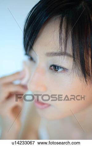 A young woman applying makeup, close-up View Large Photo Image Stock Photo - A young woman applying makeup, close-up. Fotosearch