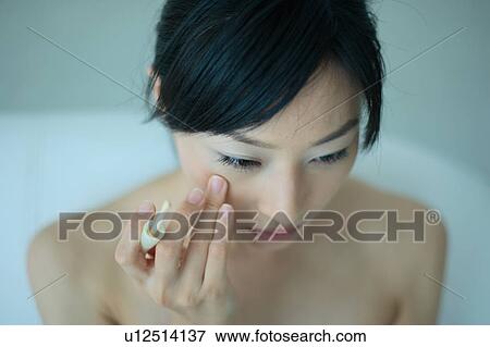 A young woman applying makeup View Large Photo Image Stock Photo - A young woman applying makeup. Fotosearch