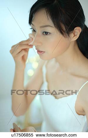 A young woman applying makeup View Large Photo Image Stock Photography - A young woman applying makeup. Fotosearch