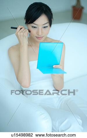 A young woman applying makeup with brush View Large Photo Image Stock Image - A young woman applying makeup with brush. Fotosearch
