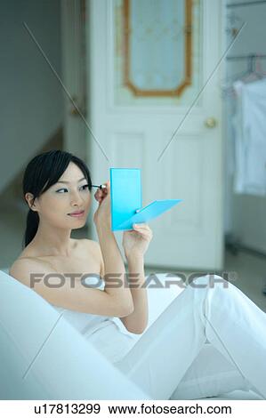 A young woman applying mascara View Large Photo Image Stock Photo - A young woman applying mascara. Fotosearch