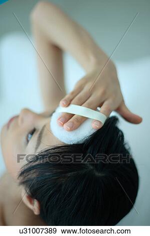 A young woman looking up and applying makeup View Large Photo Image Stock Photo - A young woman looking up and applying makeup. Fotosearch