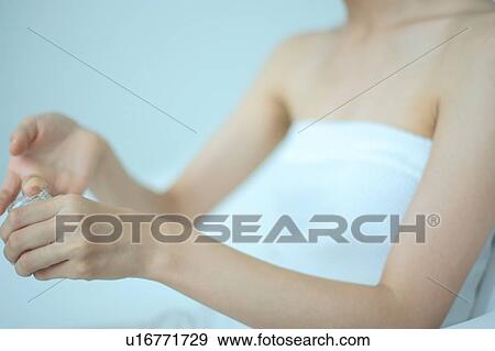 A young woman putting moisturizer into hand View Large Photo Image Stock Photo - A young woman putting moisturizer into hand. Fotosearch