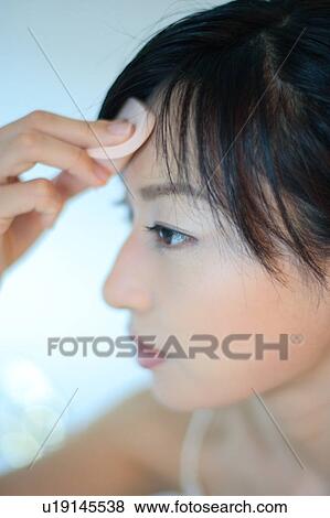 Profile of a young woman applying makeup, close-up View Large Photo Image Stock Photo - Profile of a young woman applying makeup, close-up. Fotosearch