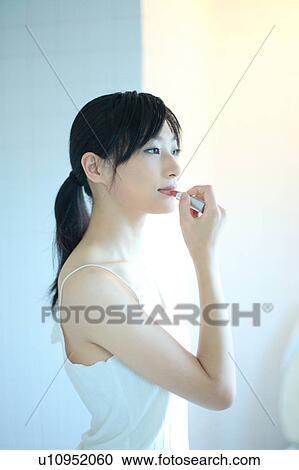Stock Image - Profile of a young woman wearing lipstick. Fotosearch