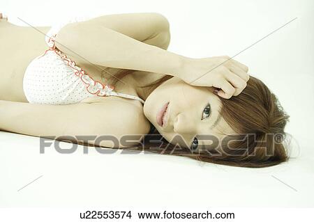 Picture - A young woman in bikini lying down. Fotosearch