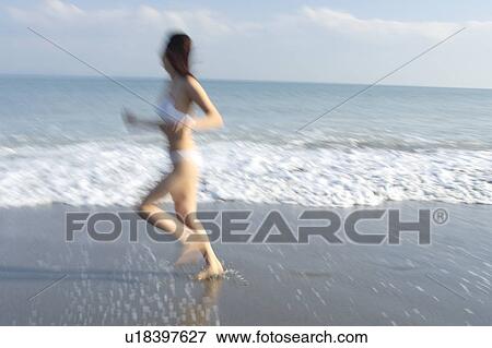 A young woman in bikini running at beach, blurred motion View Large Photo Image Stock Photo - A young woman in bikini running at beach, blurred motion. Fotosearch