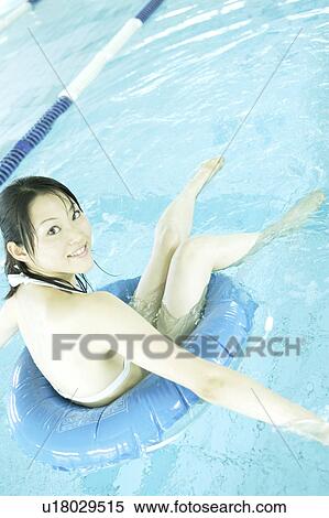 A young woman playing with inner tube in pool View Large Photo Image Stock Photography - A young woman playing with inner tube in pool. Fotosearch