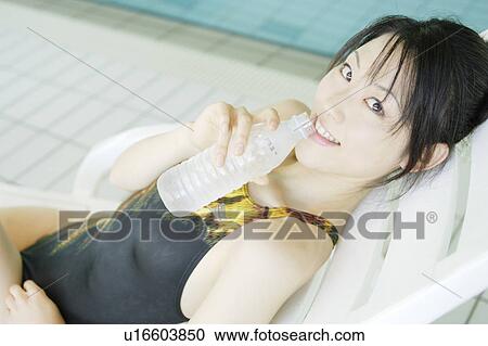Stock Image - Portrait of a young woman at poolside. Fotosearch