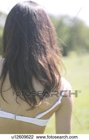 Stock Image - Portrait of a young woman in bikini, rear view. Fotosearch