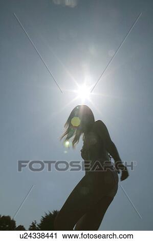 Stock Image - Portrait of a young woman in bikini, low angle view. Fotosearch