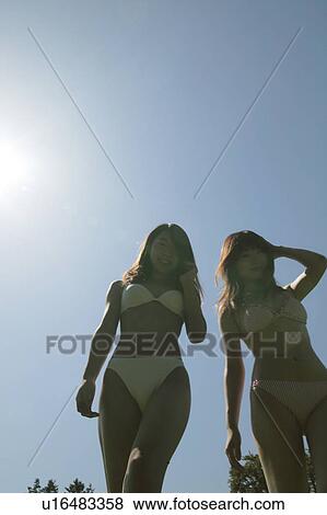 Portrait of two young women in bikini, low angle view View Large Photo Image Stock Photo - Portrait of two young women in bikini, low angle view. Fotosearch