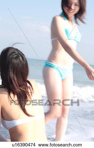 Picture - Two young women enjoying surf. Fotosearch