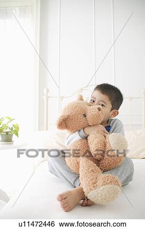 A boy holding stuffed animal Stock 