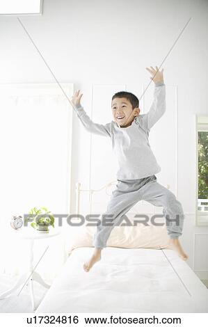 A boy jumping in bed View Large Photo Image Stock Photograph - A boy jumping in bed. Fotosearch