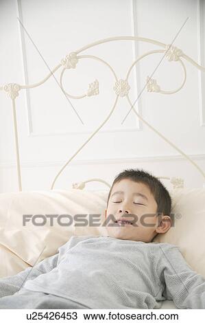 A boy sleeping in bed View Large Photo Image Stock Image - A boy sleeping in bed. Fotosearch