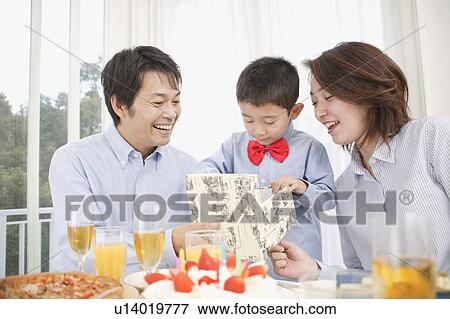 Boy opening birthday present View Large Photo Image Stock Photo - Boy opening birthday present. Fotosearch
